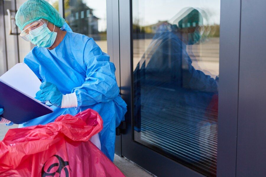 Biohazard waste disposal professional reads waste disposal guidelines.